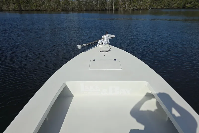 Slide: The Image of 1988 Lake & Bay Boca Grande 20 boat on calm water, featuring a trolling motor. - 5