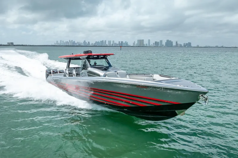 The Image of 2022 Nor-Tech 500 Sport Center Console cruising on open water with city skyline backdrop. - 0