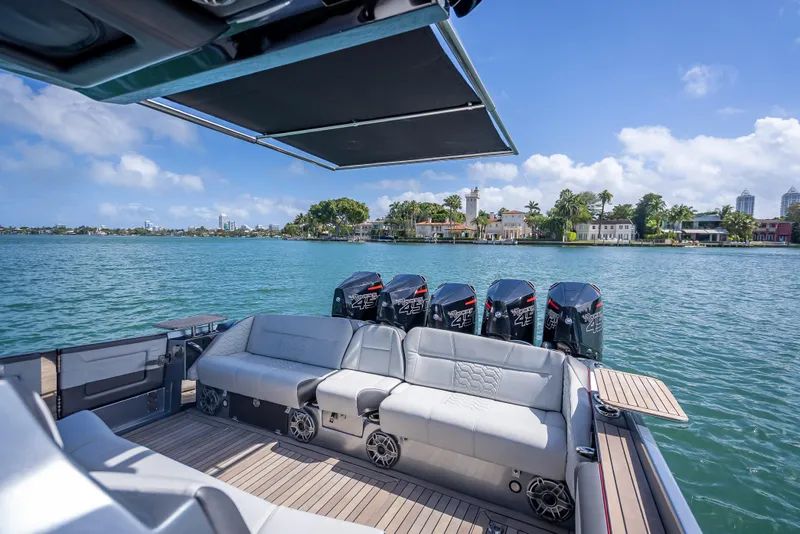 Slide: The Image of 2022 Nor-Tech 500 Sport Center Console boat with luxurious seating and powerful engines on a sunny day. - 15