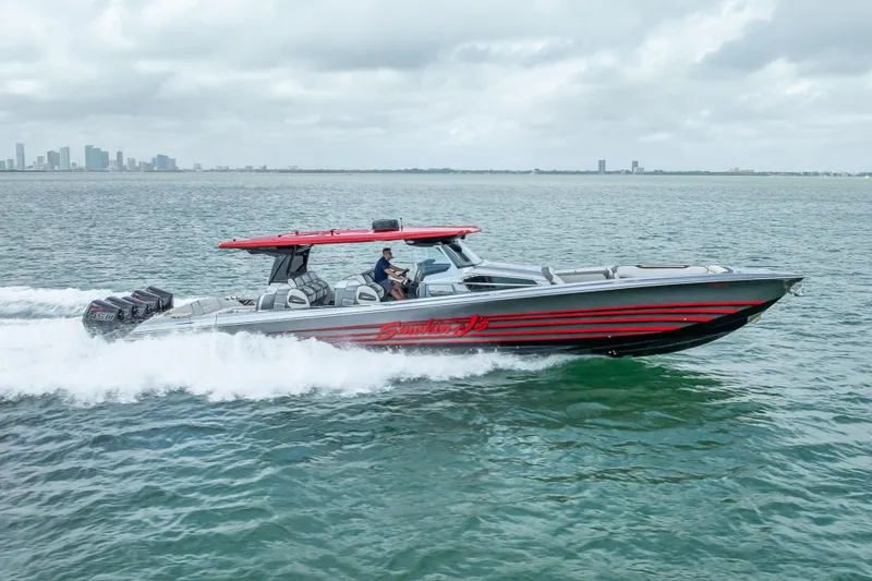Slide: The Image of 2022 Nor-Tech 500 Sport Center Console boat cruising on open water, city skyline in background. - 32
