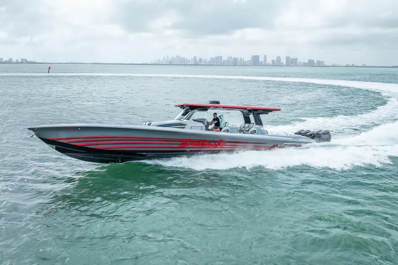 Slide: The Image of 2022 Nor-Tech 500 Sport Center Console cruising on open water with city skyline backdrop. - 37