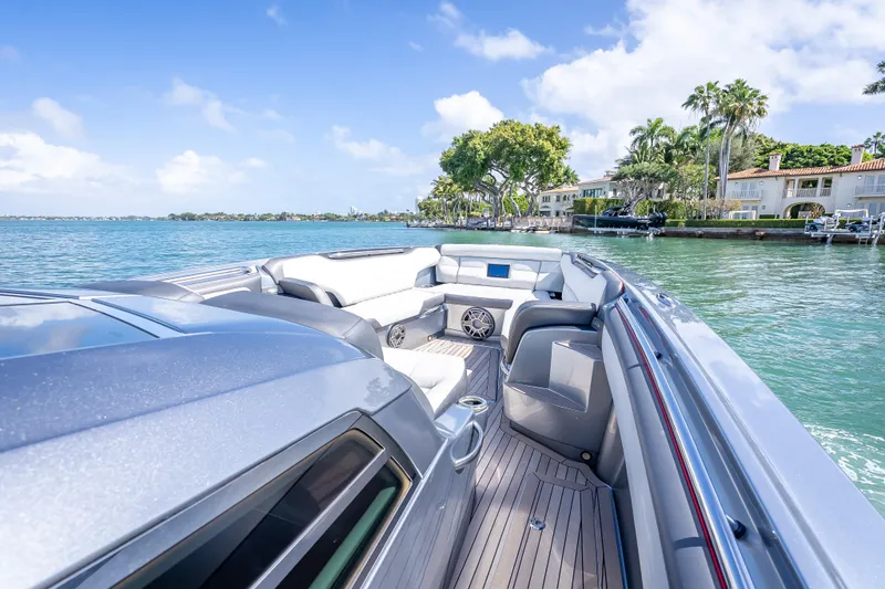 Slide: The Image of 2022 Nor-Tech 500 Sport Center Console on serene water, luxury seating, coastal backdrop. - 47