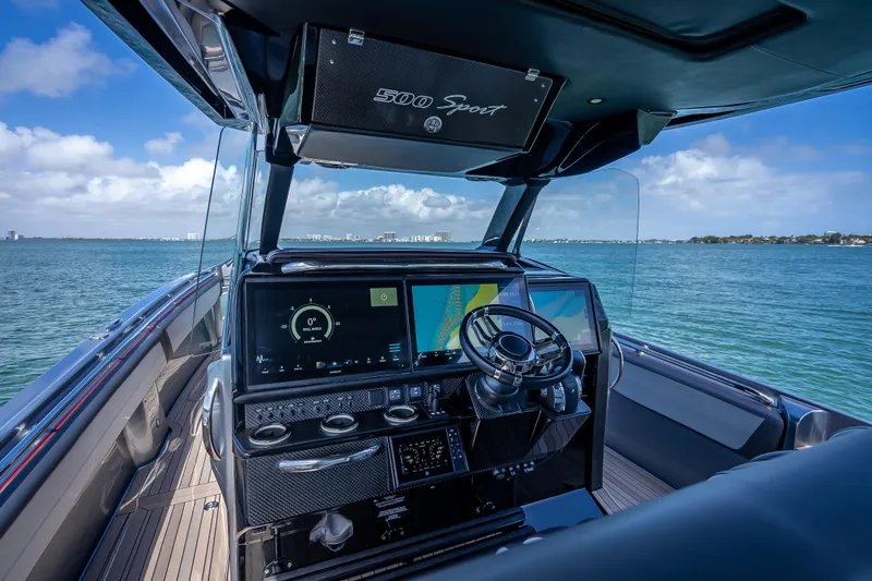 Slide: The Image of 2022 Nor-Tech 500 Sport Center Console boat interior with advanced navigation system on open water. - 6