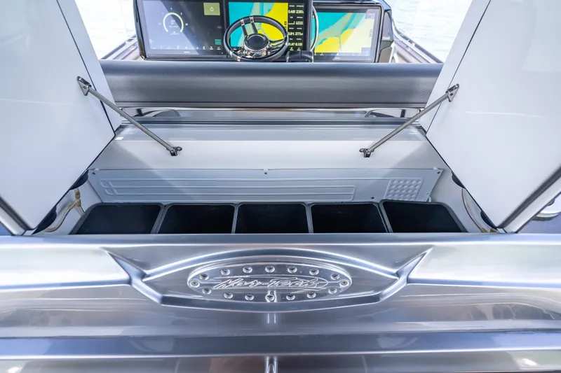 Slide: The Image of 2022 Nor-Tech 500 Sport Center Console storage compartment with open lids and dashboard view. - 88