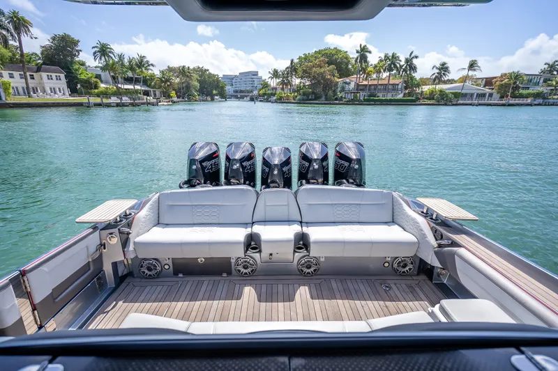 Slide: The Image of 2022 Nor-Tech 500 Sport Center Console boat with multiple engines on a scenic waterway. - 90