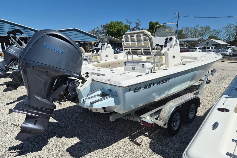 Slide: The Image of 2026 Key West 230 Bay Reef boat on trailer under clear blue sky. - 1