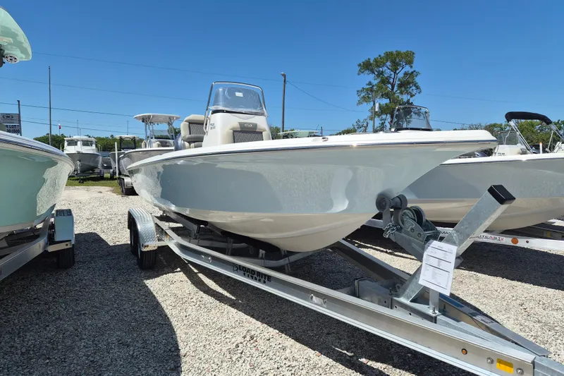 Slide: The Image of 2026 Key West 230 Bay Reef boat with outboard motor and storage compartments. - 2