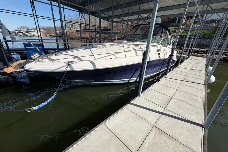 The Image of 2006 Sea Ray 340 Sundancer docked at a marina under a covered structure. - 0