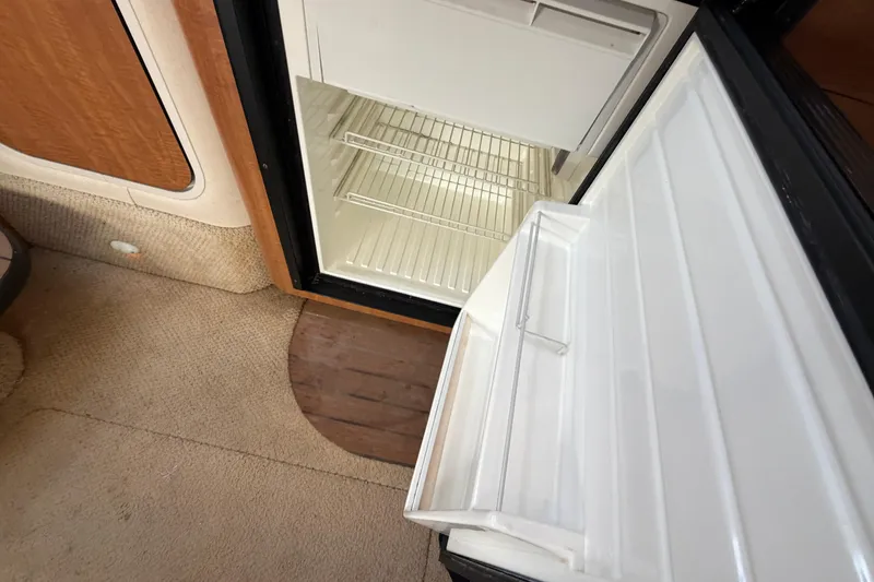 Slide: The Image of Open refrigerator inside 2006 Sea Ray 340 Sundancer boat, showcasing interior shelving. - 17