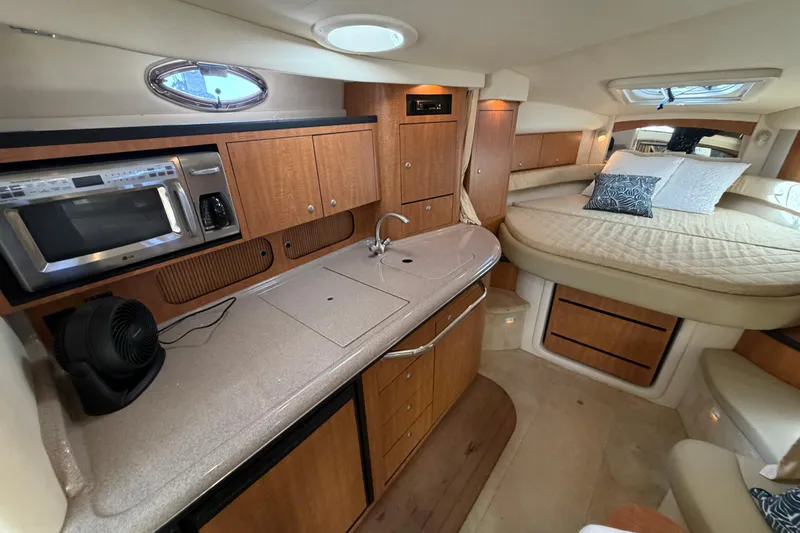 Slide: The Image of Luxurious 2006 Sea Ray 340 Sundancer cabin interior with kitchenette and cozy sleeping area. - 18