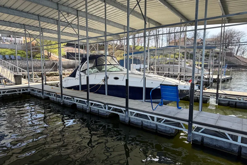 Slide: The Image of 2006 Sea Ray 340 Sundancer docked in a marina under a covered slip. - 2