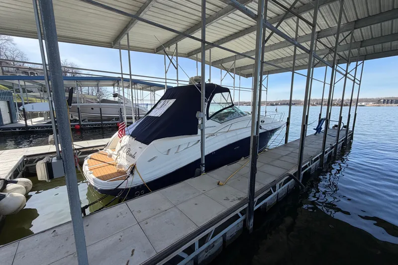 Slide: The Image of 2006 Sea Ray 340 Sundancer docked under a covered marina on a sunny day. - 3