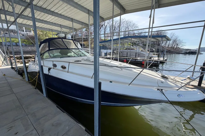 Slide: The Image of 2006 Sea Ray 340 Sundancer docked under a covered marina on a sunny day. - 4