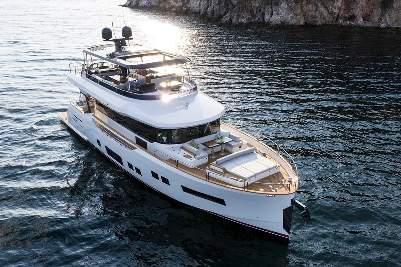 The Image of Luxurious 2026 Sirena 68 yacht cruising on serene waters near rocky coastline. - 0