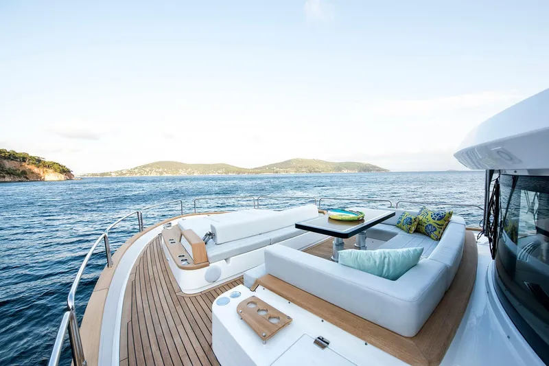 Slide: The Image of Luxurious Sirena 68 yacht deck with seating, ocean view, and scenic coastline, 2026 model. - 12