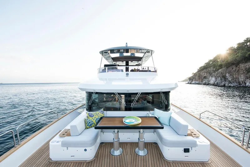 Slide: The Image of Luxurious 2026 Sirena 68 yacht with elegant deck seating, cruising near a scenic coastline. - 14