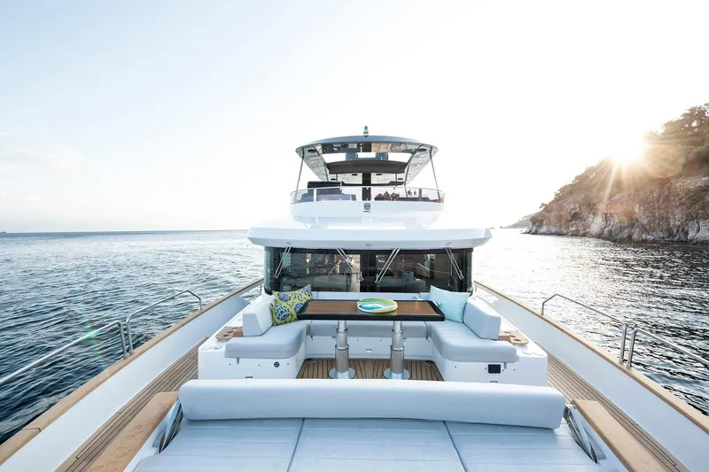 Slide: The Image of Luxurious 2026 Sirena 68 yacht cruising near rocky coastline at sunset. - 15