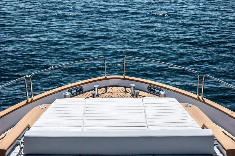 Slide: The Image of Bow view of 2026 Sirena 68 yacht with sunbed, overlooking calm ocean waters. - 20