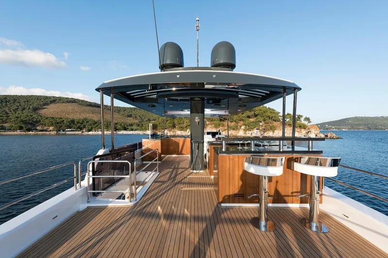 Slide: The Image of Luxurious Sirena 68 yacht deck with bar stools, overlooking serene coastal waters, 2026 model. - 36