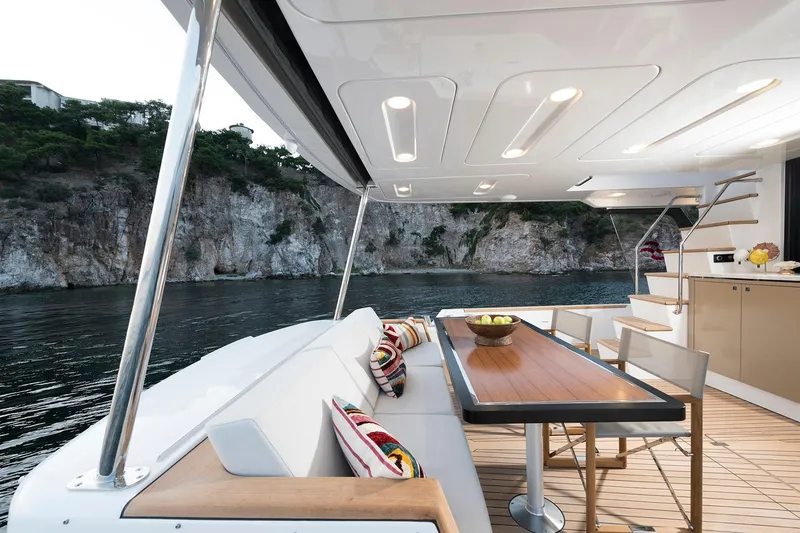 Slide: The Image of Luxurious Sirena 68 yacht deck with elegant seating, wooden table, and scenic coastal view, 2026 model. - 44