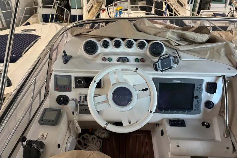 Slide: The Image of Control panel of a 2008 Azimut 47 yacht with navigation instruments and steering wheel. - 12