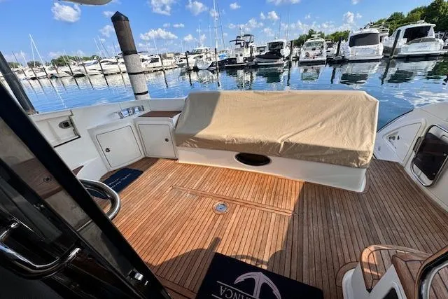 Slide: The Image of 2008 Azimut 47 yacht deck with wooden flooring, docked at a marina under a clear sky. - 9
