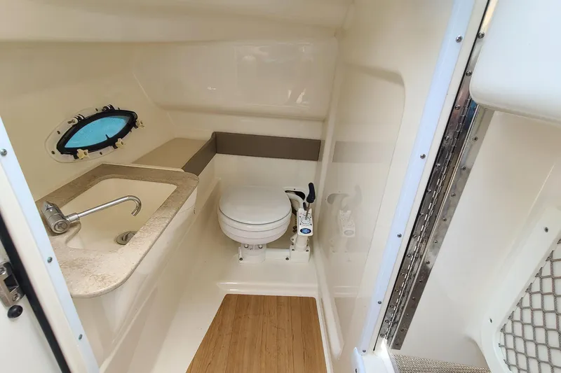 Slide: The Image of 2015 Formula 270 Bowrider boat bathroom with sink, toilet, and porthole window. - 13