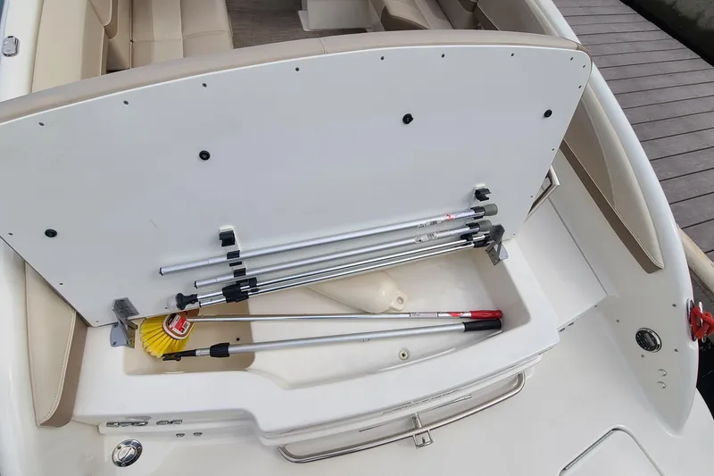 Slide: The Image of Open storage compartment on a 2015 Formula 270 Bowrider boat with cleaning tools. - 22