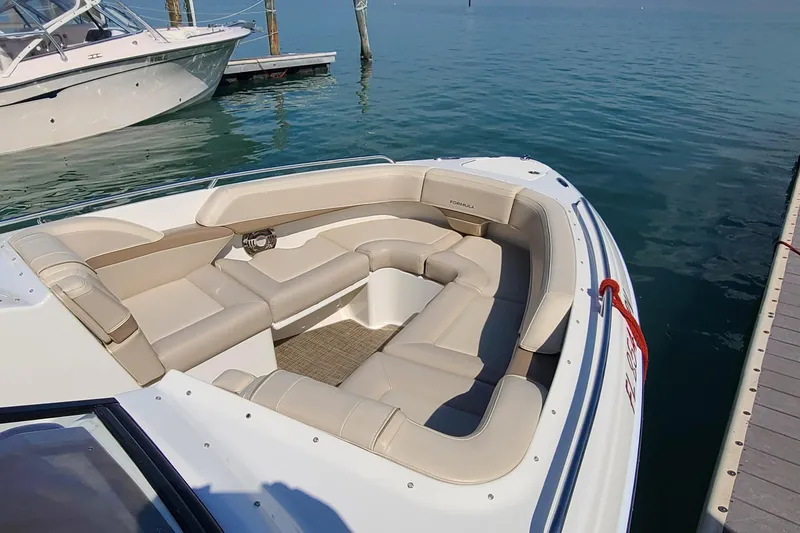 Slide: The Image of 2015 Formula 270 Bowrider boat with beige seating, docked on calm water. - 4
