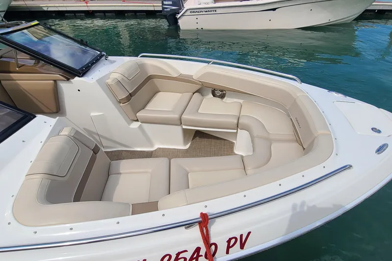 Slide: The Image of 2015 Formula 270 Bowrider boat with beige seating, docked on clear water. - 5