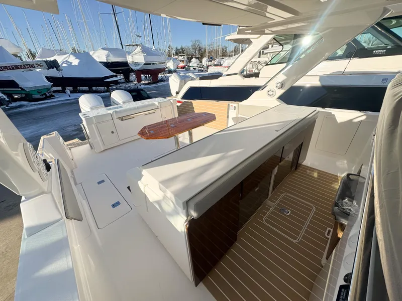 Slide: The Image of 2025 Tiara Yachts 43 LS luxury yacht deck with seating and table, docked in marina. - 15