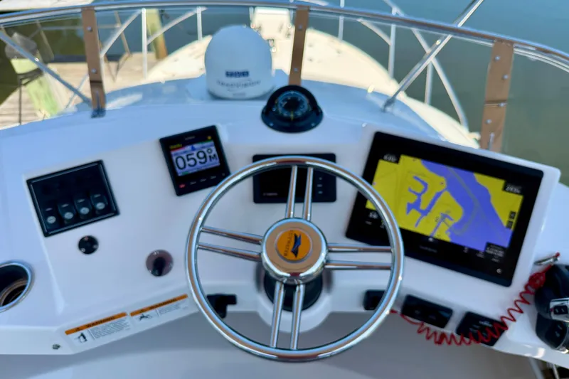 Slide: The Image of 2022 Cutwater C-32 CB boat helm with navigation screens and steering wheel. - 12