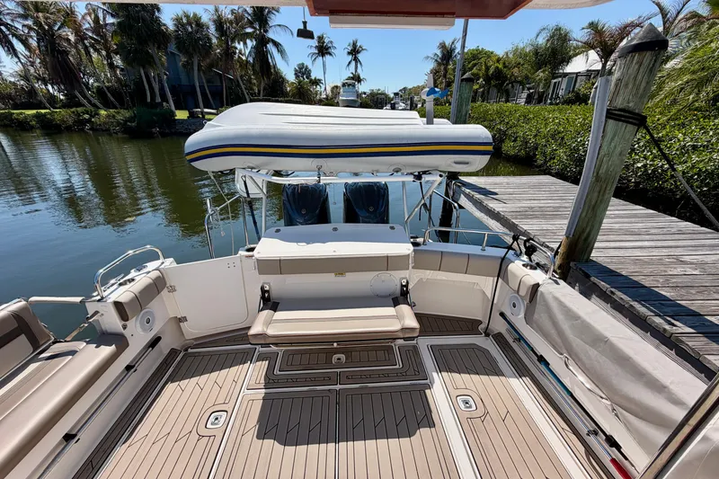 Slide: The Image of 2022 Cutwater C-32 CB boat docked, featuring spacious deck and seating area. - 16