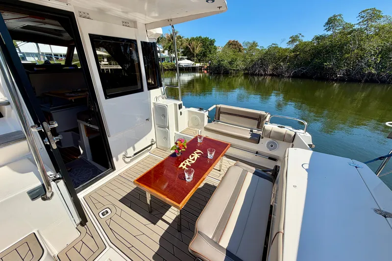 Slide: The Image of 2022 Cutwater C-32 CB boat deck with seating, table, and scenic water view. - 24