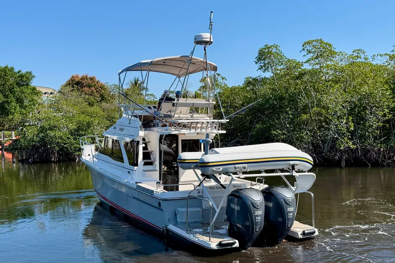 Slide: The Image of 2022 Cutwater C-32 CB boat cruising on a calm river surrounded by lush greenery. - 3