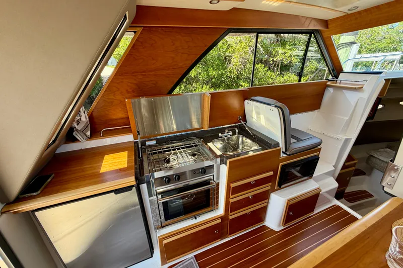 Slide: The Image of 2022 Cutwater C-32 CB boat interior with modern kitchen and wooden accents. - 31