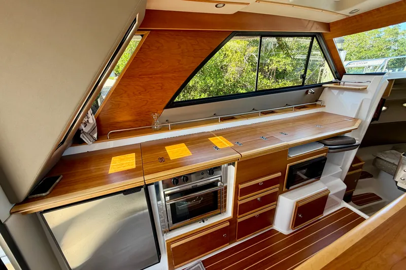Slide: The Image of Interior of 2022 Cutwater C-32 CB yacht featuring a modern kitchen with wood accents. - 32