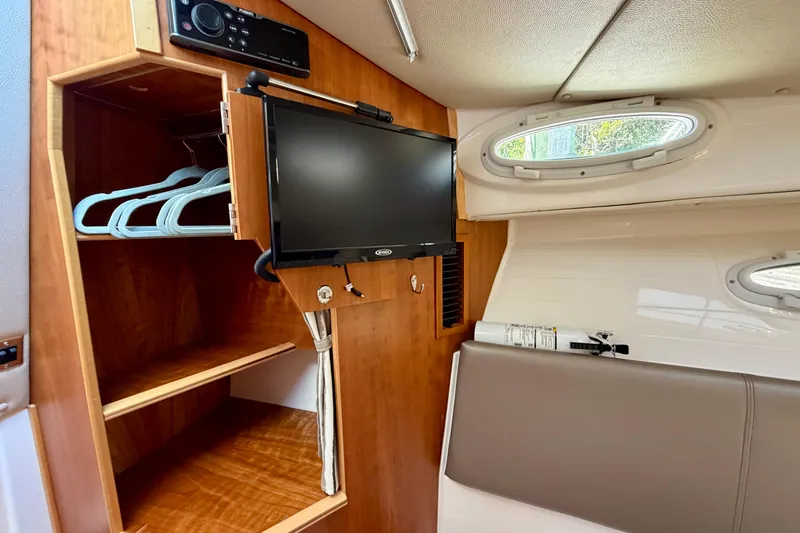 Slide: The Image of 2022 Cutwater C-32 CB cabin interior with TV, storage, and porthole windows. - 42
