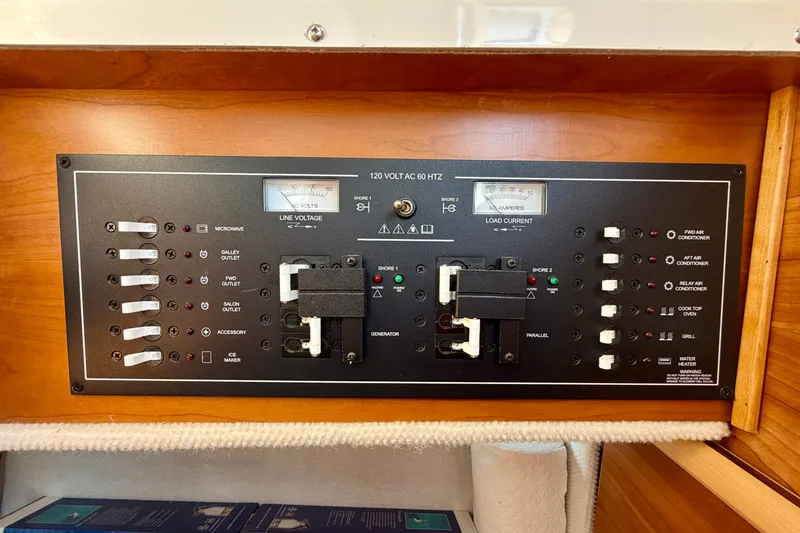Slide: The Image of Electrical control panel on a 2022 Cutwater C-32 CB boat, featuring various switches and meters. - 46