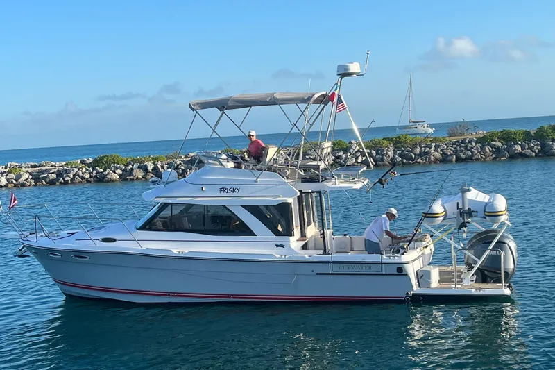 Slide: The Image of 2022 Cutwater C-32 CB boat cruising on a sunny day near rocky shoreline. - 58