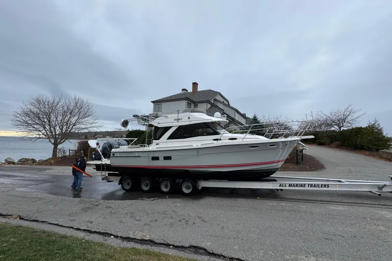 Slide: The Image of 2022 Cutwater C-32 CB boat on trailer near waterfront home, overcast sky. - 59