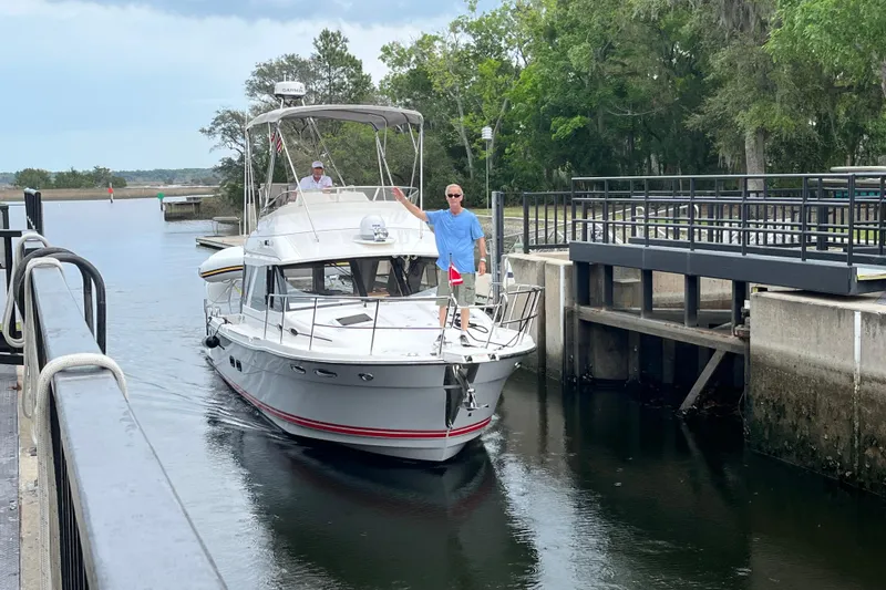 Slide: The Image of 2022 Cutwater C-32 CB boat navigating a canal lock with two people on board. - 60