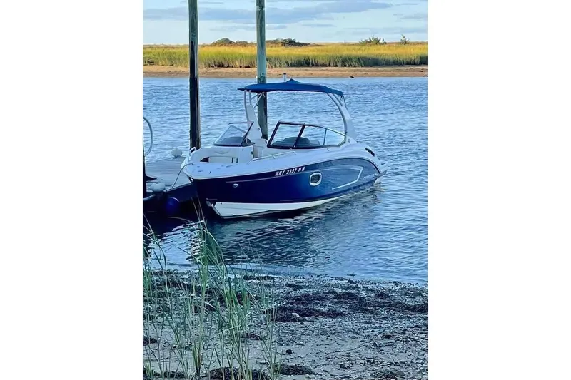 The Image of 2017 Chaparral 257 SSX boat docked on calm water with scenic background. - 0
