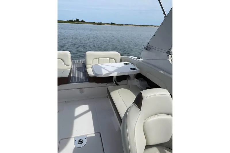 Slide: The Image of 2017 Chaparral 257 SSX boat interior with seating and table on calm water. - 2