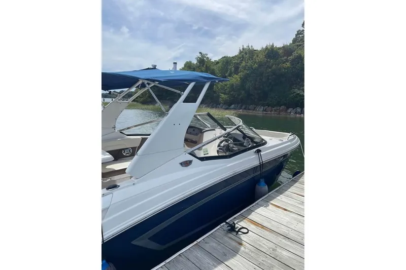 Slide: The Image of 2017 Chaparral 257 SSX boat docked by a scenic lakeside with lush greenery. - 4