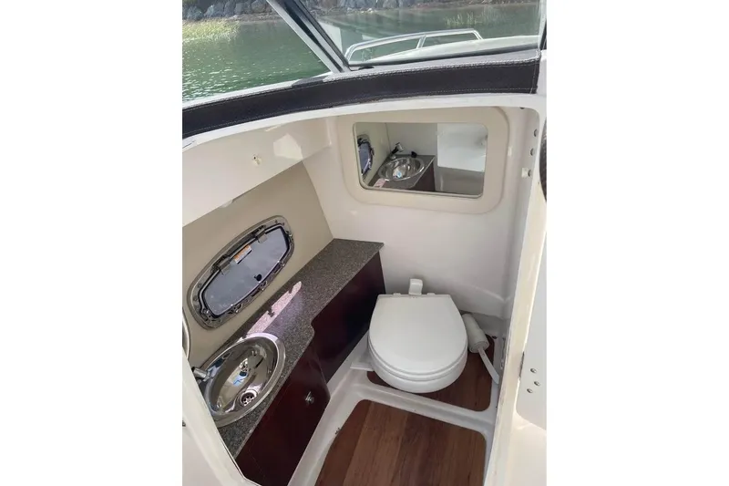 Slide: The Image of 2017 Chaparral 257 SSX boat interior with toilet, sink, and mirror. - 9