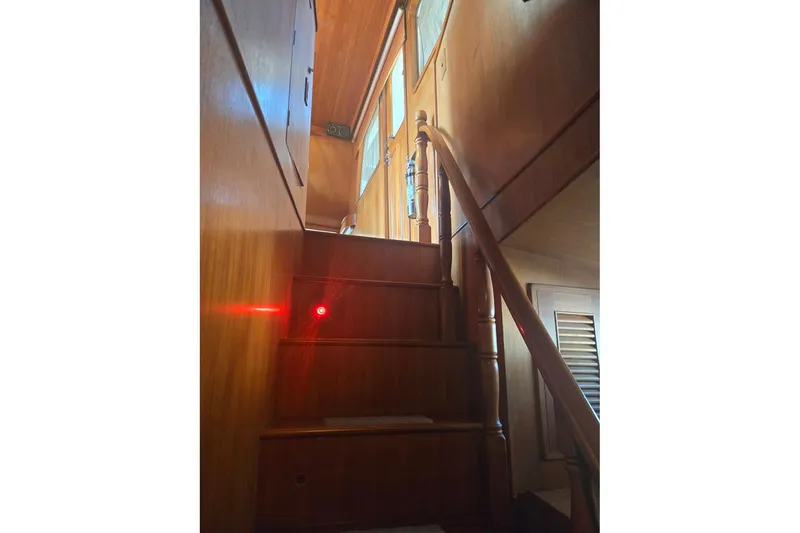 Slide: The Image of Wooden staircase inside 1982 Ocean Alexander 50 Mark I yacht, featuring warm lighting. - 14
