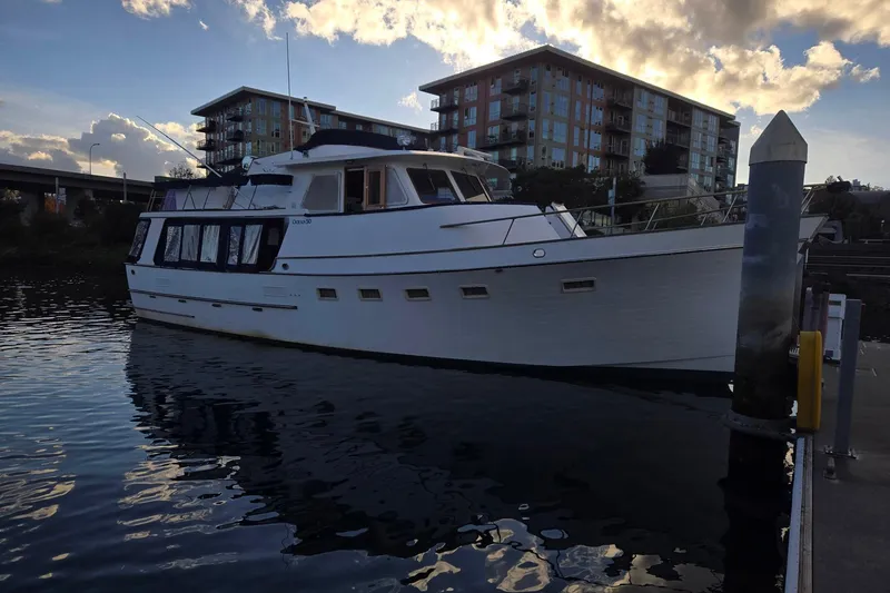 Slide: The Image of 1982 Ocean Alexander 50 Mark I yacht docked near modern buildings at sunset. - 3