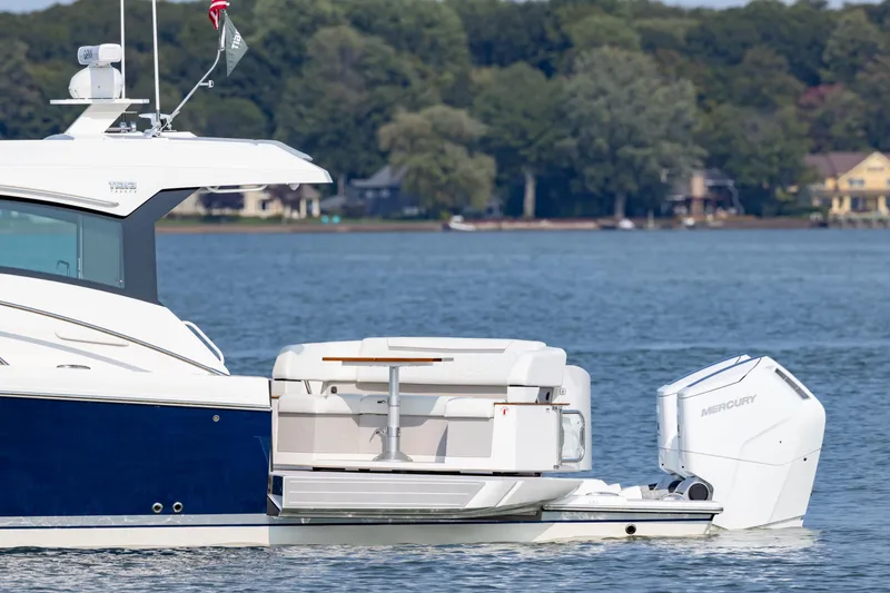 Slide: The Image of 2025 Tiara Yachts 43 LE on a serene lake with lush green shoreline. - 13