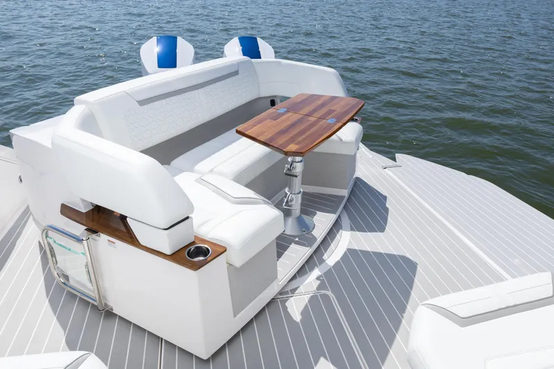 Slide: The Image of 2025 Tiara Yachts 43 LE luxury boat seating area with wooden table on water. - 14